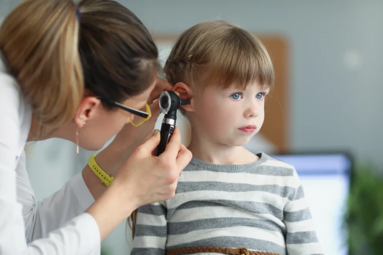 Paediatrician examining a child ear
